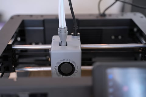 Close up of 3D printer is working at workshop. Engineering, technology.