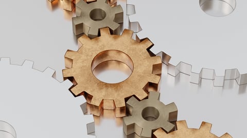 Close-up of several interlocking metallic gears on a reflective steel surface.