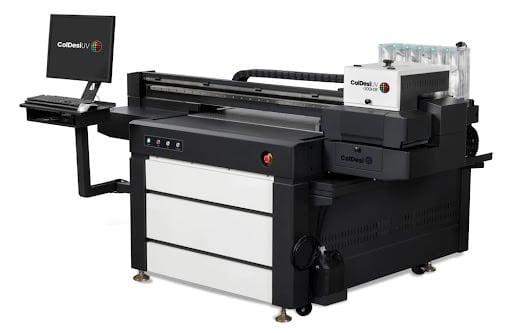Industrial UV flatbed printer with black frame, white paper drawers, and attached computer monitor displaying the Corbett brand logo